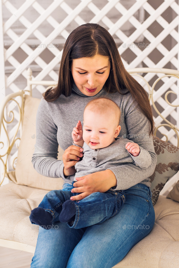 Loving mother playing with her baby in the room - Stock Photo - Images