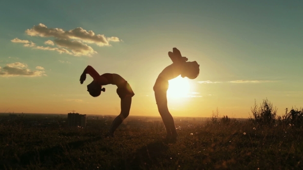 Couple Practicing Yoga in the Park at Sunset - Drop Back, Wheel Pose