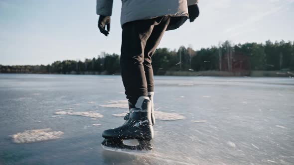 Man Practice Ice Skating on a Clear Frozen Lake on Sunny Day Making Ice Sparkle alt