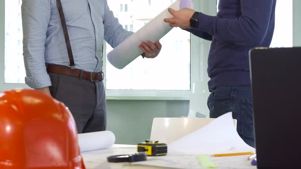 Architect Gives a Roll of Building Plans To His Colleague alt