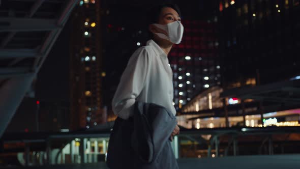 Asia businesswoman in fashion office clothes wear medical face mask walking alone.