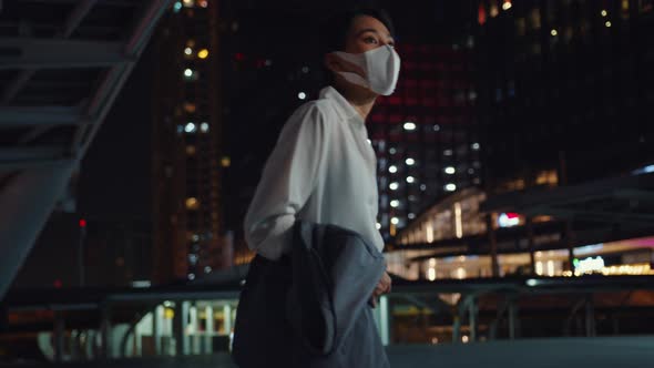 Asia businesswoman in fashion office clothes wear medical face mask walking alone. alt