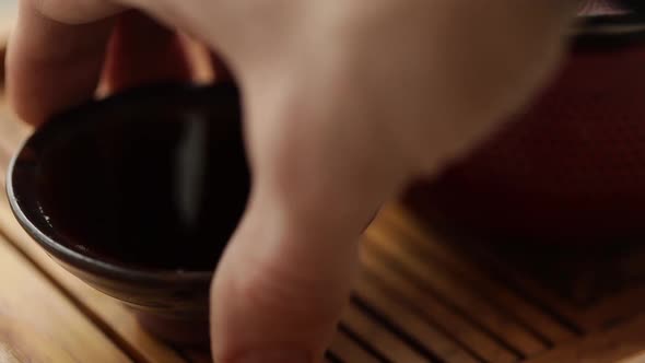 a Man Takes a Bowl of Tea From the Table