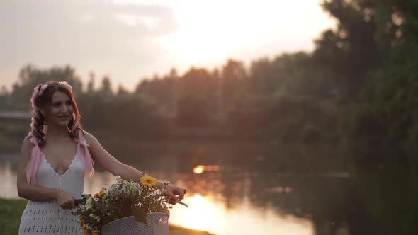 Attractive Woman in White Dress Riding in Park Near Lake