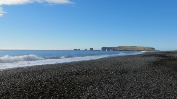 View of Cape Dyrholaey From Black Sand Beach in Iceland in Sunny Calm Weather