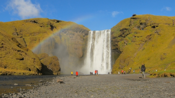 Beautiful Icelandic Landscape with Famous Waterfall Skogafoss, Rainbow Is Over River in Sunny Day
