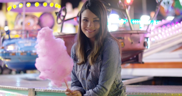 Happy Young Woman Enjoying a Night at a Fair alt