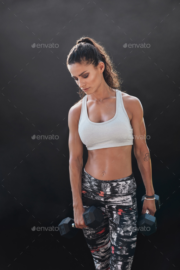 Bodybuilding model exercising with heavy dumbbells