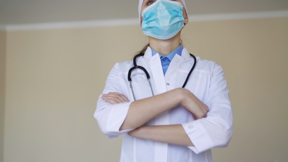 Female Medical Worker Wearing Face Mask Looking Into Camera alt