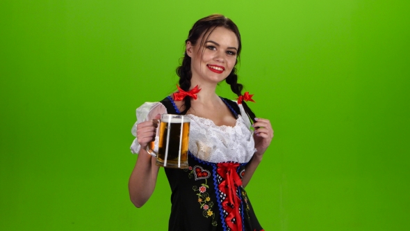Woman in Bavarian Costume Dances with a Glass of Beer in the Pickup. Green Screen alt