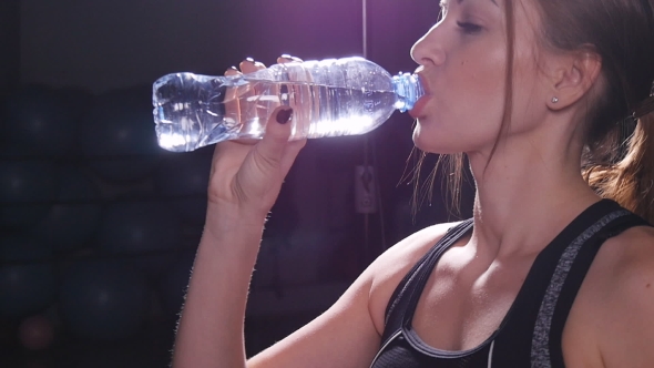 Young Fit Woman Drinking Water at Gym alt