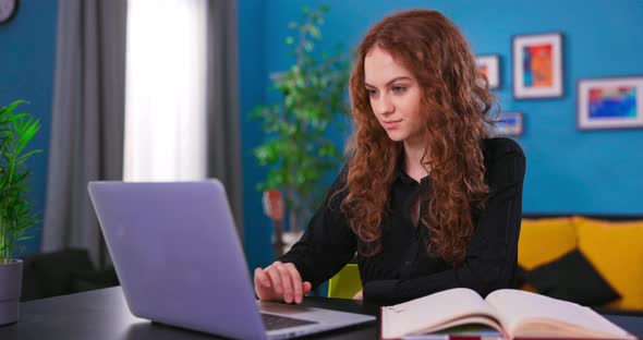 Beautiful Caucasian Girl with Curly Hair Sitting at a Desk in a Cozy Living Room alt