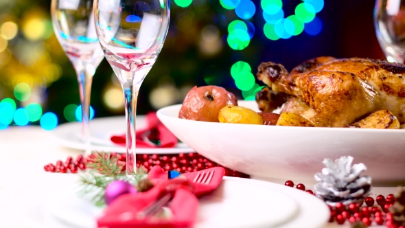 Roasted Chicken on Christmas Table in Front of Fireplace and Tree with Lights