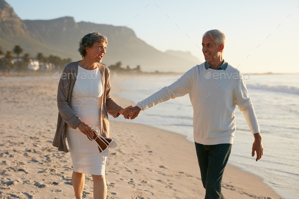 Loving mature couple strolling on the beach. - Stock Photo - Images
