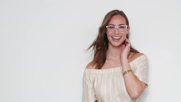 Portrait of a Brown-Haired Model Smiling While Fixing Her Eyeglasses