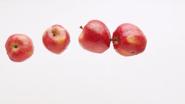 Many Red Apples Filmed on a White Background Jump Up and Flyfor a Tasty Juice alt