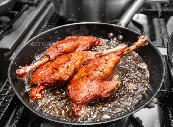 Goose drumstick frying in a pan