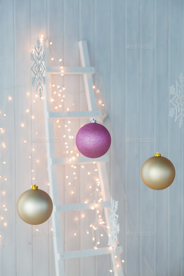 Christmas lights burning on a white wooden background. Stock Photo by