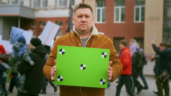 Face Portrait of Activist with Green Screen Banner Looking at Camera