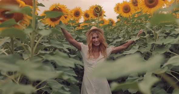 Happy Girl Whirls in a Sunflower Field and Laughs