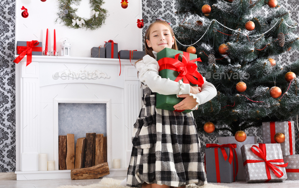 Beautiful child girl and christmas present indoors - Stock Photo - Images