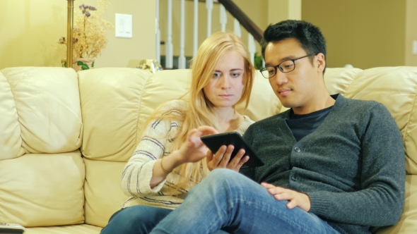 Young Multi-ethnic Couple Relaxing at Home, Use the Tablet2 alt