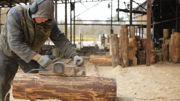 Construction Worker Planing a Piece of Wood for a Building Project. Construction Grinds Electric