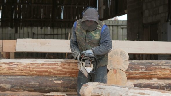 Man Cuts Wood Chainsaw for Future Home