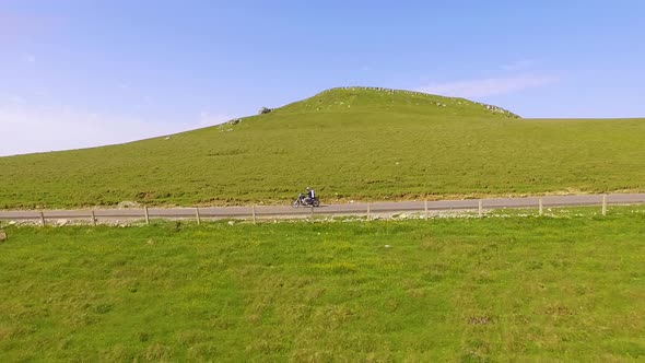 Motorcyclist driving his motorbike on the mountain road in the mountain country side. alt