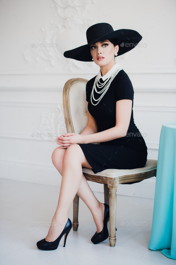 Elegant woman in black dress with a hat ...