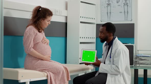 Male Doctor Holding Horizontal Greenscreen on Tablet Display alt