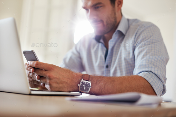 Yung businessman using mobile phone at home - Stock Photo - Images