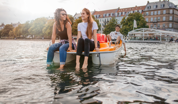 Teenage friends enjoying boating in the lake - Stock Photo - Images
