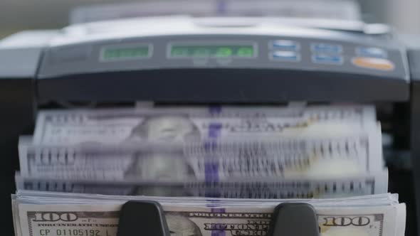 Closeup shot of money counting machine with 100 dollar bills.