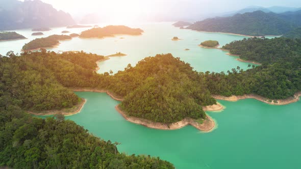 A drone flying over a dam in a beautiful tropical forest. alt