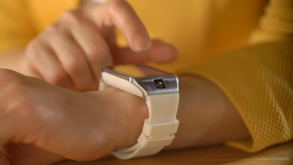 Woman's Hand Touching the Screen of a Smart Watch