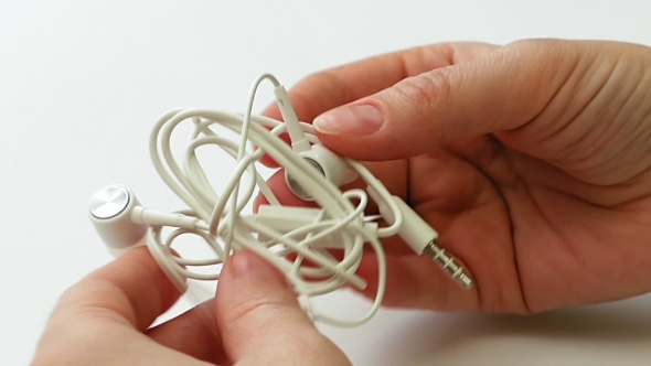 Woman Untangles Tangled Earbuds or Earphone Knot