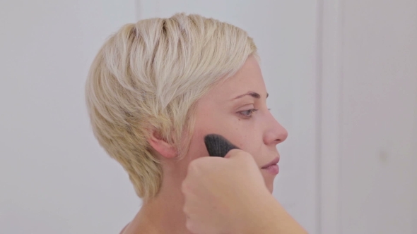 Make-up Artist Applying Makeup on the Face of the Sensual Model