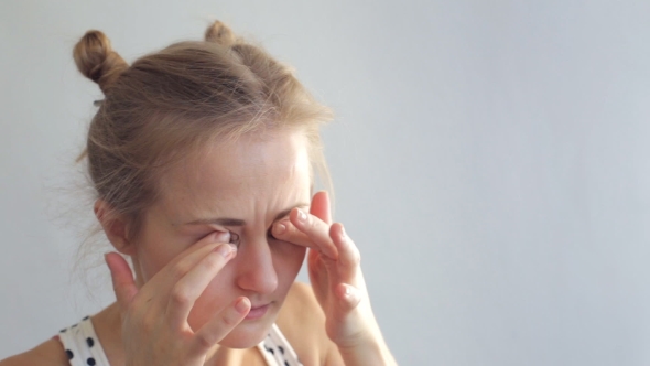 Young Woman Rubs Her Eyes