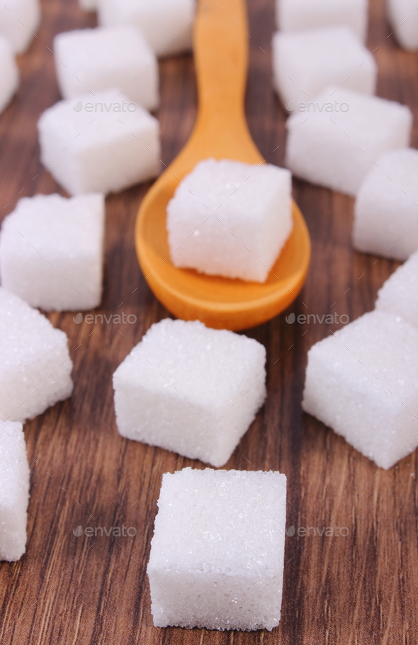 Wooden spoon with cubes of sugar on wooden background Stock Photo by ratmaner