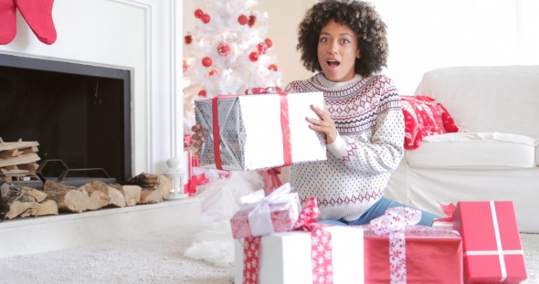 Surprised Woman Holding a Large Christmas Gift alt