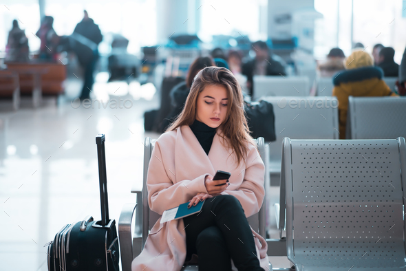 Airport business woman waiting in terminal. Stock Photo by NomadSoul1