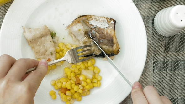 Lady Is Using Utensils To Cut Meal in Small Bites