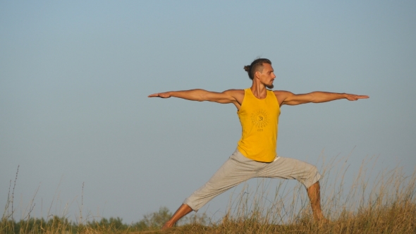 Practicing Yoga Moves And Positions In Nature Young Sporty Man Practicing Yoga Moves And Positions In Nature Young Sporty Man