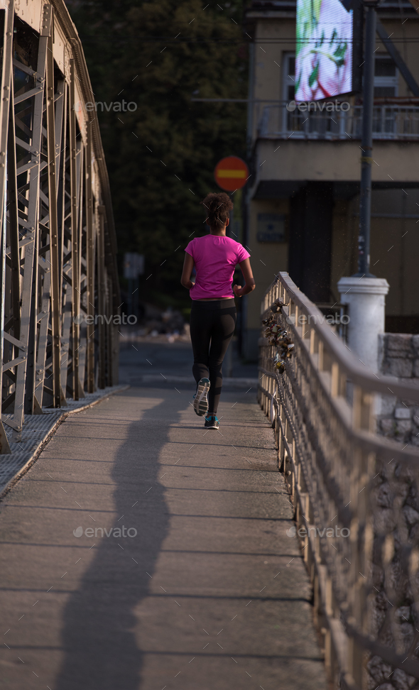 african american woman running across the bridge - Stock Photo - Images