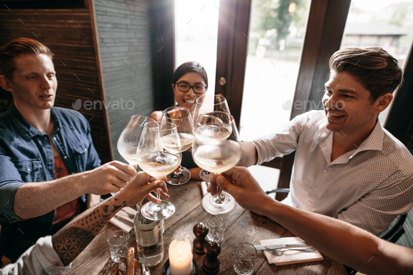 Group of people toasting wine at restaurant