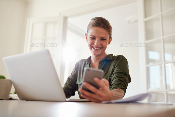 Woman using smart phone and smiling - Stock Photo - Images