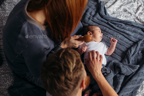 Young parents giving of attention to their baby. - Stock Photo - Images