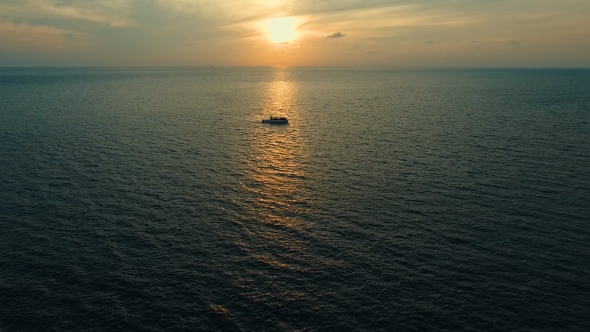 Aerial: Lonely Boat at Sunset in the Sea
