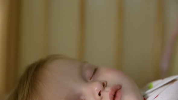 Sleeping Baby in Bed in White Pajamas with Colored Circles